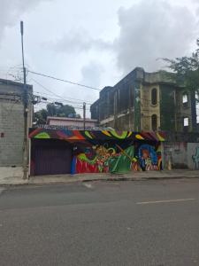 a building covered in graffiti on the side of a street at Pousada UFPE INN in Recife