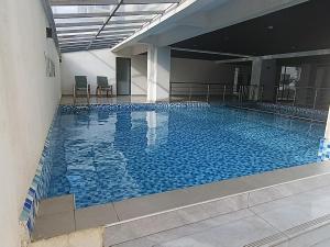 a large swimming pool in a building at Fun-fantastic Furnished Apartment, The Loftel near UN, Embassies, Two Rivers & Village Market,with a Pool and Gym in Nairobi