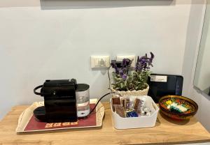 a table with a coffee maker and a vase of flowers at MONOLOCALE VICINO MILANO1 in Lodi