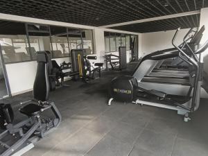 a gym with several treadmills and machines in it at Fun-fantastic Furnished Apartment, The Loftel near UN, Embassies, Two Rivers & Village Market,with a Pool and Gym in Nairobi