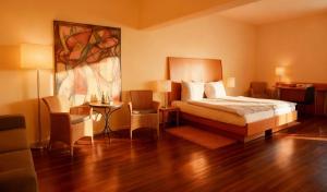 a bedroom with a bed and a table and chairs at Hotel Ambiente in Dortmund