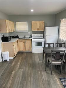 a kitchen with wooden cabinets and a table and a refrigerator at Oakhill Oasis guest house in Moores Mills