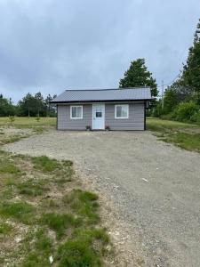 a small house in the middle of a gravel lot at Oakhill Oasis guest house in Moores Mills