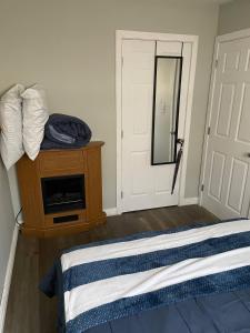 a bedroom with a bed and a mirror and a door at Oakhill Oasis guest house in Moores Mills