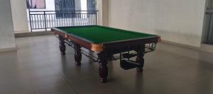 a green pool table sitting on a tile floor at Fun-fantastic Furnished Apartment, The Loftel near UN, Embassies, Two Rivers & Village Market,with a Pool and Gym in Nairobi