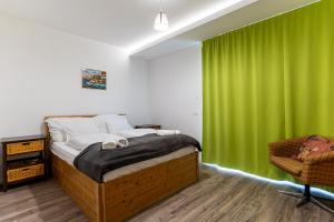 a bedroom with a bed and a green curtain at KJB Vendégház Dombori in Fadd-Dombori