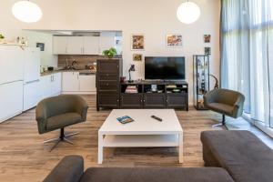 a living room with a couch and chairs and a table at KJB Vendégház Dombori in Fadd-Dombori