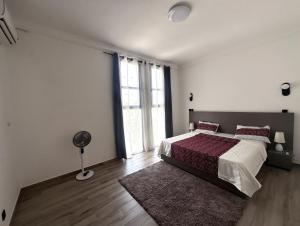 a white bedroom with a bed and a fan at Villa Solaya in Bamako +24 photos