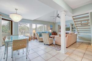 a dining room and living room with a spiral stair at Spinnaker 716 in Seabrook Island