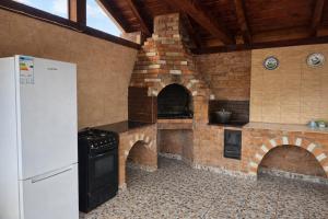 a kitchen with a brick oven and a refrigerator at Casa de vacanta Naty in Colibiţa