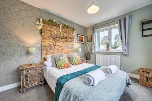 a bedroom with a bed with towels on it at Winterbourne House in Fleet