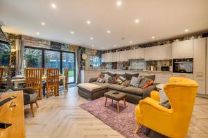 a living room with a couch and a kitchen at Winterbourne House in Fleet