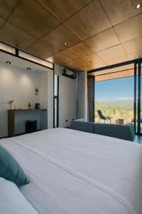 a bedroom with a large bed and a large window at Boutique Hotel Bodega CICLO ANDINO in Perdriel +63 photos