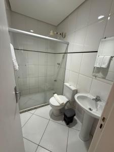 a white bathroom with a toilet and a sink at Prado Hotel in Salgueiro +45 photos