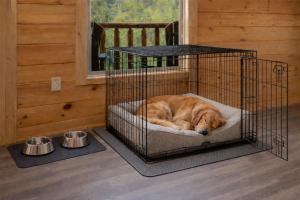 a dog sleeping in a cage in a room at Hibearnator in Sevierville