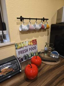 a counter top with apples and cups and a tv at Ferienwohnung Salut in Saarbrücken