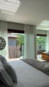 a bedroom with a large bed with a large window at Cipó Lofts - 3 lofts incríveis na Serra do Cipó in Santana do Riacho +61 photos