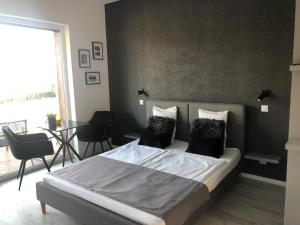 a bedroom with a bed and a table with chairs at LigetResidence Apartman in Fonyód