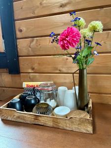 a wooden tray with a vase with flowers in it at Landelijk gelegen houten huisje in Opperdoes