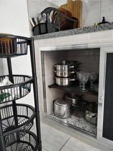a kitchen with pots and pans on a shelf at Casa Zago 1 in Santa Maria Madalena +14 photos