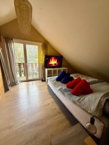 a bedroom with a bed with red and blue pillows at Le Petit Chalet avec hottub. in Sint-Gillis-Waas