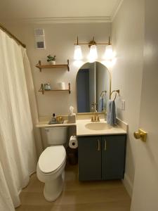a bathroom with a toilet and a sink and a mirror at Pearl on the Point in Carolina Beach +29 photos