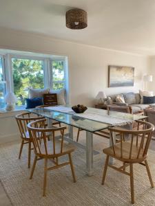 a living room with a glass table and two chairs at Pearl on the Point in Carolina Beach