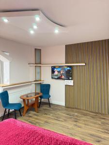 a room with two chairs and a tv on a wall at Riverside Apartment in Lugoj