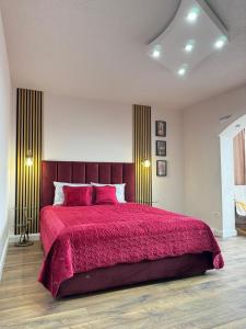 a bedroom with a large bed with a red bedspread at Riverside Apartment in Lugoj +2 photos