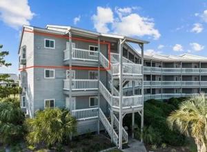 a large apartment building with stairs in front of it at Pearl on the Point in Carolina Beach