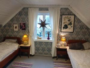 a bedroom with two beds and a window at Flintegården Kårhus in Borgund