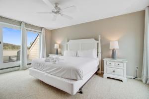 a white bedroom with a white bed and a window at Spinnaker 753 in Seabrook Island