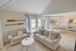 a living room with two couches and a table at Spinnaker 753 in Seabrook Island +13 photos