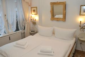 a white bed with white pillows and a mirror at Haus Schaper in Westerland