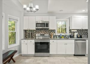 a kitchen with white cabinets and a stove top oven at Pocono nirvana in East Stroudsburg