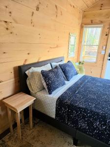 a bedroom with a bed and a wooden wall at Tiny Home Big View! in Franklin