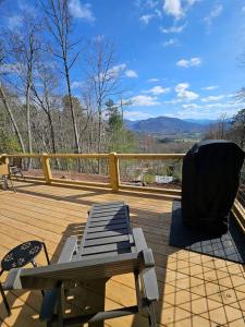 a wooden deck with a picnic table and a chair at Tiny Home Big View! in Franklin