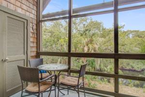 a porch with a table and chairs and a window at Mariner's Watch 4267 in Kiawah Island