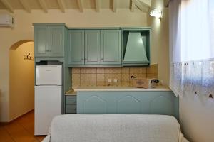 a kitchen with green cabinets and a white refrigerator at Anatoli Villa in Steni Vala Alonissos +29 photos