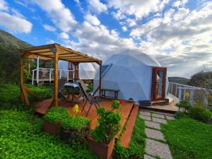 a large dome tent in a yard with plants at Agriturismo Glamping Erbe Matte in SantʼAntìoco