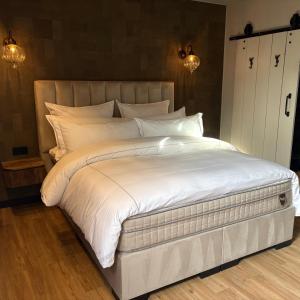 a large white bed with white sheets and pillows at 1920Renesse in Renesse