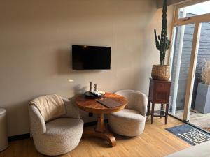 a living room with two chairs and a table and a tv at 1920Renesse in Renesse
