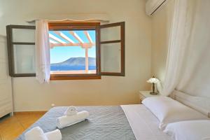 a bedroom with a bed and a window with a view at Anatoli Villa in Steni Vala Alonissos