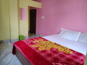 a bedroom with a bed with a red and yellow blanket at Shivmandir Homestay in Siliguri