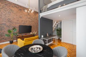 a living room with a dining room table and a brick wall at Selah Residence in Oradea
