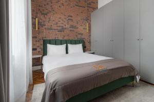 a bedroom with a large bed with a brick wall at Selah Residence in Oradea