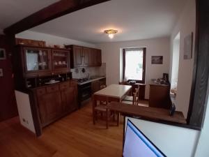 a kitchen with wooden cabinets and a table and a tv at Il quattordici in Rimasco