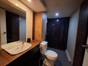 a bathroom with a white toilet and a sink at Arizona Residence in Ban Ko En