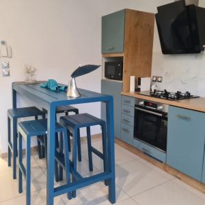 a blue kitchen with a blue table and stools at Le Pavillon du trou d'eau in La Saline les Bains