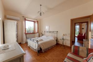a bedroom with a bed and a couch and a table at Holiday House Borgo Badia in Castiglione del Lago +67 photos
